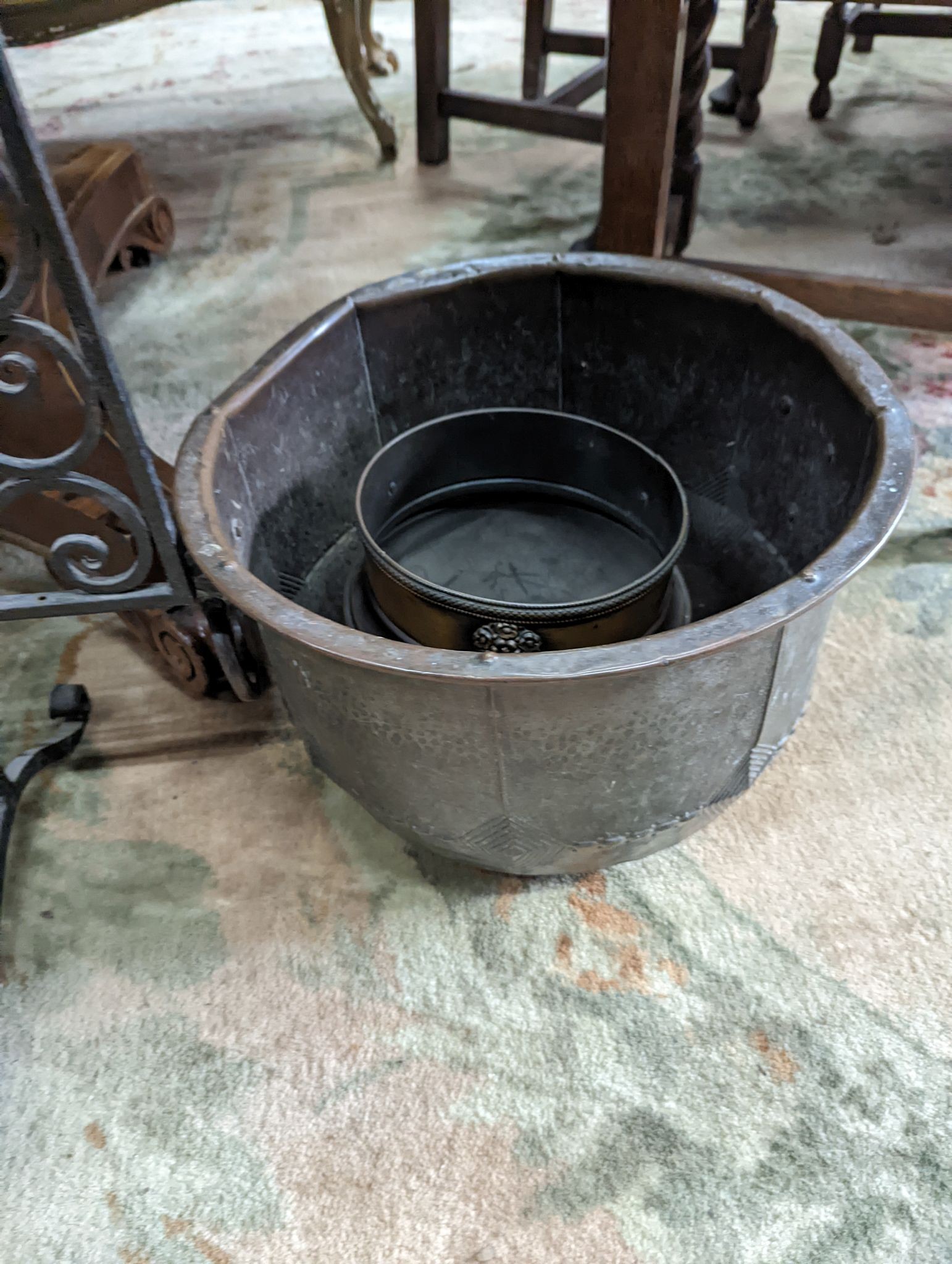 A wrought iron scroll work firescreen, width 95cm, a Dutch embossed brass scuttle, two trivets, coal bin and assorted metalware